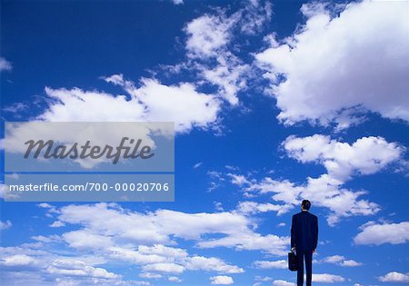 Back View of Businessman and Clouds