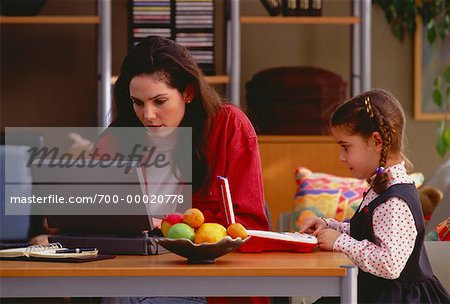 Mutter und Tochter am Tisch mit Laptop-Computern