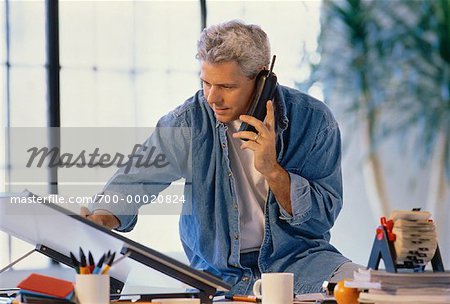 Man Using Cordless Phone at Drafting Table