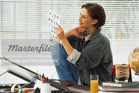 Woman Looking at Page of Slides In Home Office