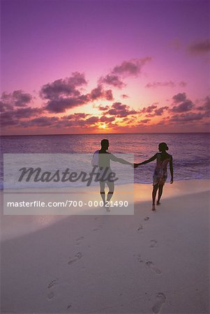 Silhouette de Couple Holding Hands sur la plage au coucher du soleil