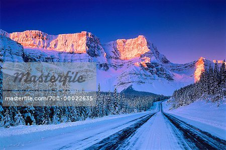 Schnee bedeckte Highway und Berg bei Sonnenaufgang Highway 93, Banff-Nationalpark in Alberta, Kanada