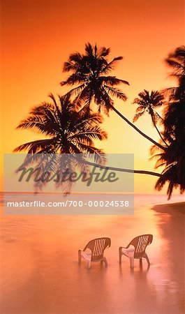 Deux chaises sur la plage au coucher du soleil avec Palm arbres Iles Maldives, océan Indien