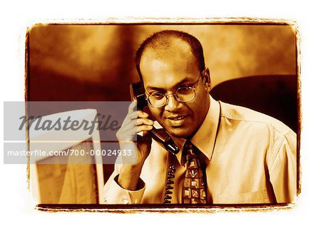 Businessman Sitting at Desk Using Phone