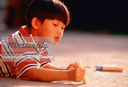Boy Drawing on Pavement with Chalk