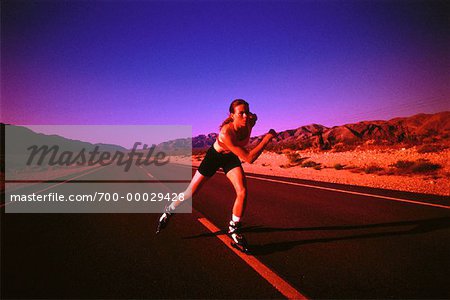 Femme patin à roues alignées sur la route au crépuscule