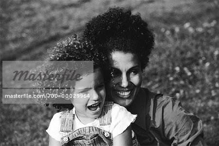 Mother Holding Daughter in Lap Outdoors