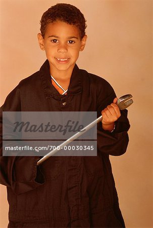 Portrait of Boy Wearing Adult's Coveralls, Holding Wrench