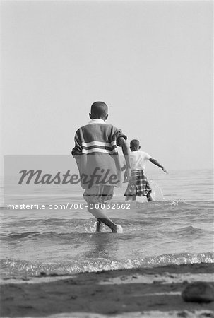 Back View of Children Running in Surf on Beach