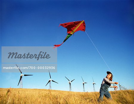 Fille de vol cerf-volant près des éoliennes