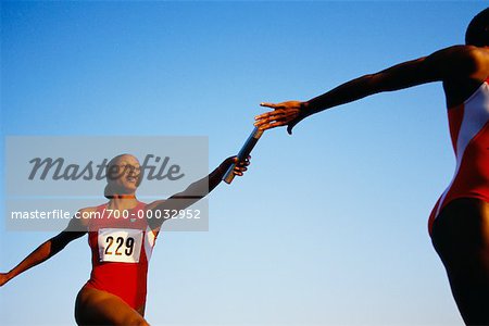 Weibliche Läufer übergeben Baton