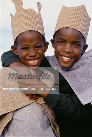 Portrait de deux garçons portant en carton des couronnes et des Capes de serviette