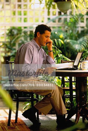 Mann mit Laptop auf Patio-Singapur