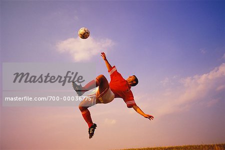 Soccer Player Jumping to Kick Ball