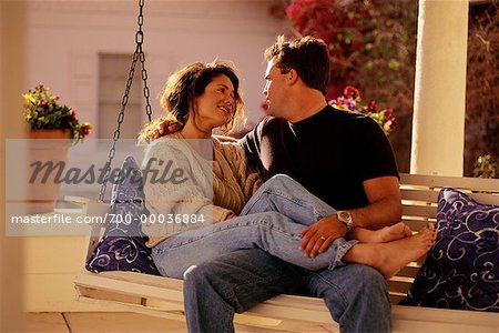 Couple assis sur le porche Swing