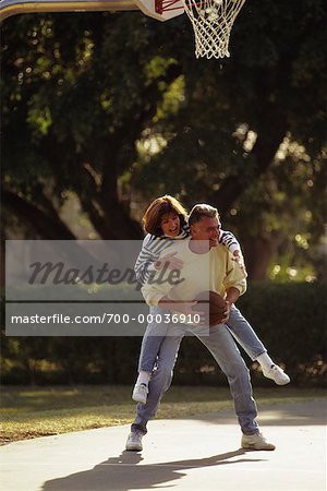 Mature Couple Playing Basketball Outdoors