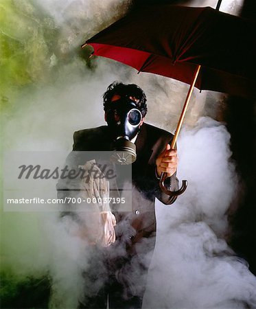 Kaufmann mit Gas-Maske hält Regenschirm