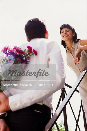 Man Giving Flowers to Woman Outdoors