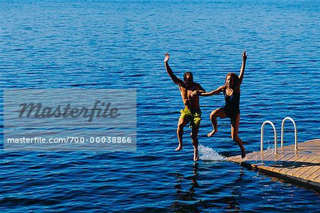 Paar in Bademode, Sprung ins Wasser vom Dock