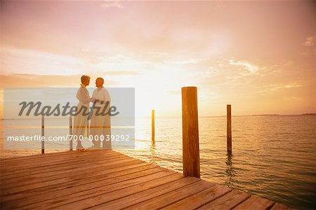 Couple d'âge mûr sur le quai au coucher du soleil