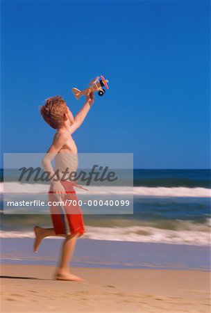 Junge in Bademode, laufen am Strand mit Toy Airplane Surfers Paradise, Australien