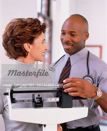 Male Doctor with Female Patient On Scale