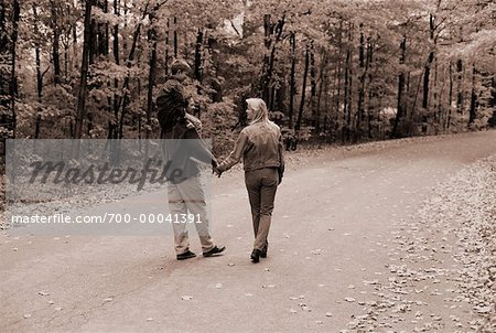 Vue arrière du famille marchant sur une route de campagne en automne