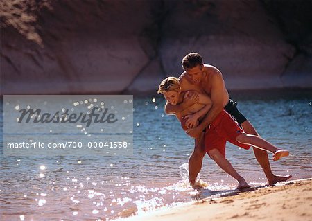 Father and Son in Swimwear Playing on Beach Lake Powell, Arizona, USA