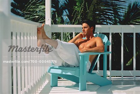 Homme assis dans une chaise longue sur le balcon