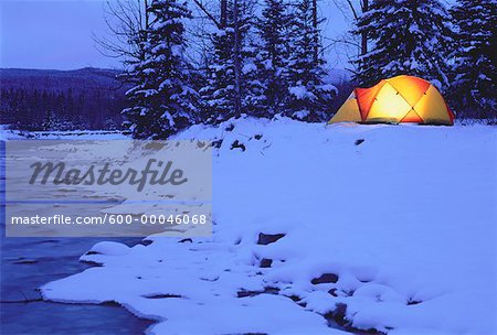 Glühende Zelt in der Nähe Fluss im Winter Kananaskis Country, Alberta Kanada