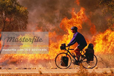 Homme d'équitation de vélo près de Bush Fire Western Australia, Australie