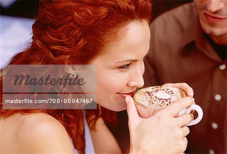 Frau hält Becher bei Outdoor-Café