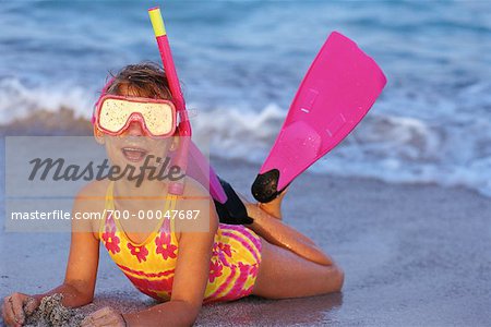 Girl in Swimwear, Lying on Beach Wearing Snorkel and Flippers