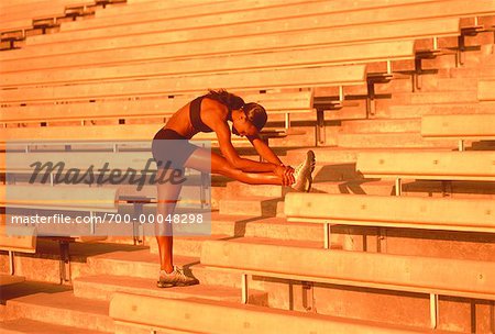 Woman Stretching on Stadium Stairs