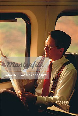 Businessman Reading Newspaper on Train