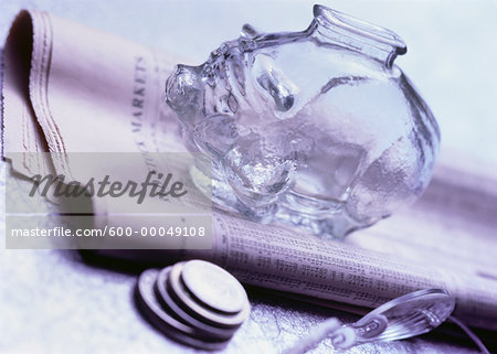 Piggy Bank on Stock Listings with Coins and Eyeglasses Piggy Bank on Stock Listings with Coins and Eyeglasses