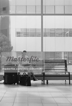 Femme d'affaires utilisant un téléphone cellulaire dans le Terminal avec bagages Toronto, Ontario, Canada