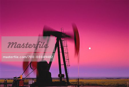 Pompe à huile prises en mouvement au crépuscule avec la pleine lune, Alberta, Canada