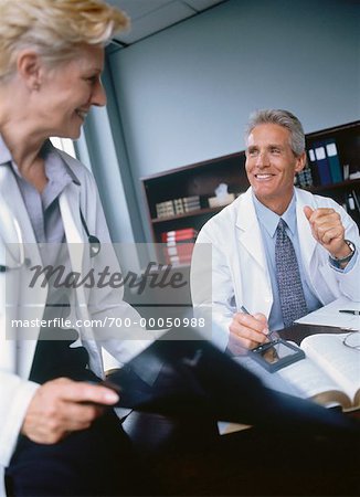 Doctors with X-Ray and Electronic Organizer in Office