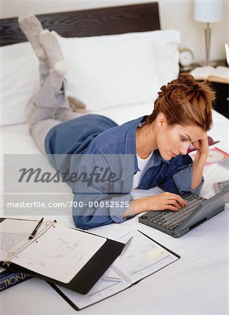 Woman Lying on Bed Using Laptop Computer