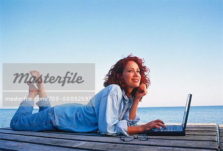 Woman Lying on Dock Using Laptop Computer