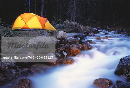 Rougeoyant tente près de cours d'eau des montagnes Rocheuses, Parc National Banff, Alberta, Canada