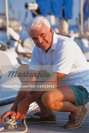 Portrait of Mature Man Tying Boat To Dock