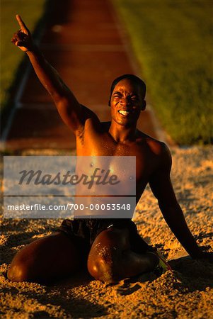 Ecstatic Man in Sand Pit after Long Jump