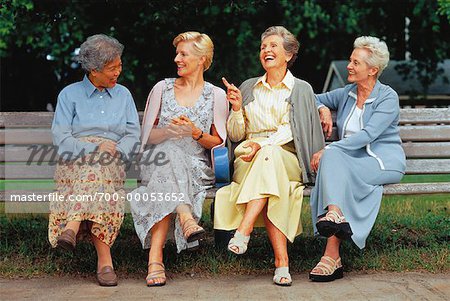 Quatre femmes mûres assis sur un banc de parc