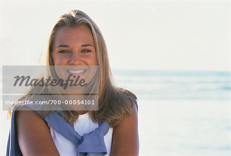 Portrait of Teenage Girl with Sweater Over Shoulders, Smiling Outdoors