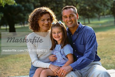 Portrait of Family Sitting on Picnic Table in Park
