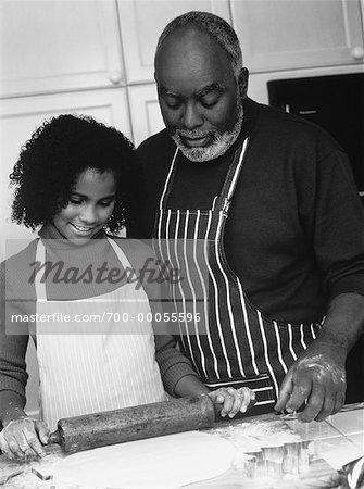 Grand-père et petite-fille dans cuisine, rouler la pâte