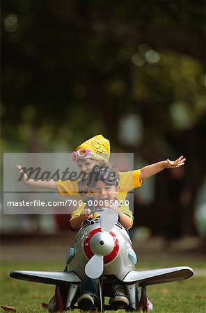 Two Children Playing with Toy Airplane Outdoors