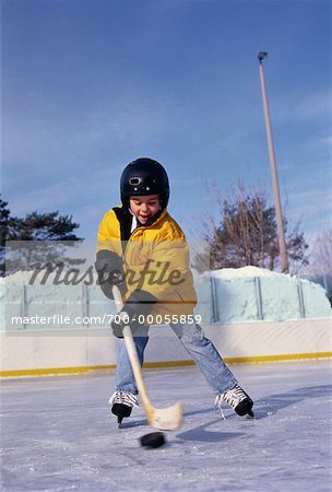 Boy Playing Hockey at Outdoor Ice Rink
